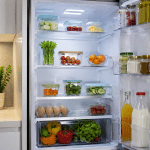 Refrigerador limpio y ordenado con alimentos frescos dispuestos de forma organizada.