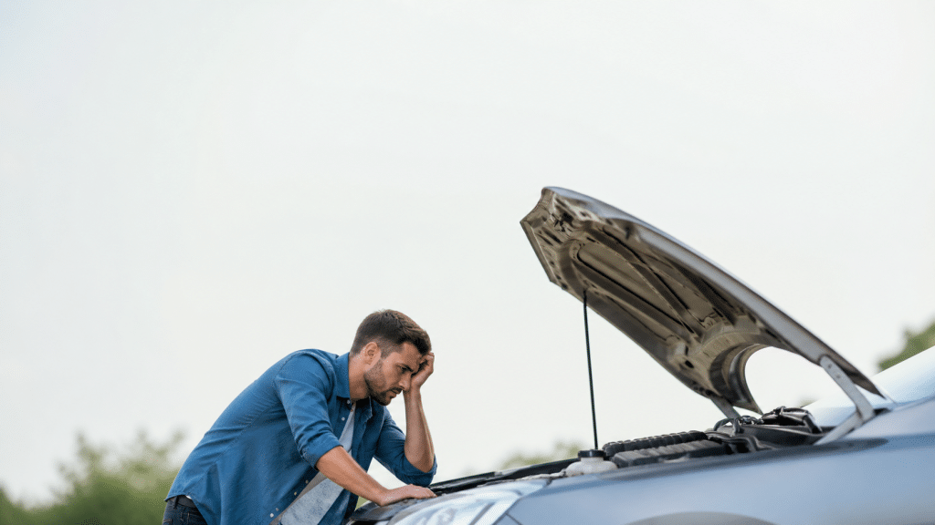 climatizzatore auto non funziona, uomo controlla motore con cofano aperto