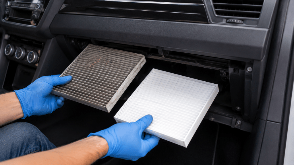 Technician replacing the cabin filter inside the dashboard