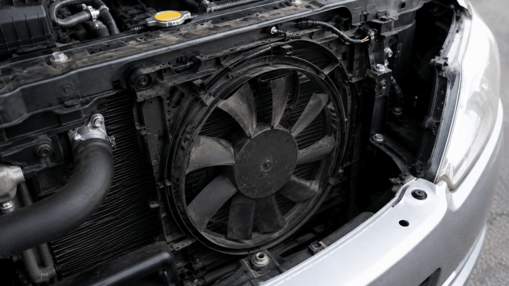 Car radiator fan faulty in engine compartment with visible cooling system