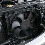 Ventilador del radiador del coche en el compartimento del motor con el capó abierto.