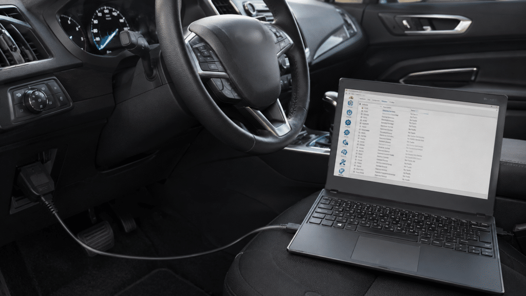 Laptop connected to a Ford via USB OBD2 adapter during a diagnosis with FORScan