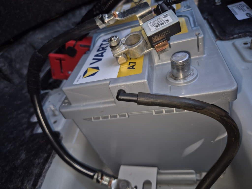 IBS sensor on the negative pole of the Varta AGM battery installed on the Ford Kuga Plug-in Hybrid during OBD2 diagnosis